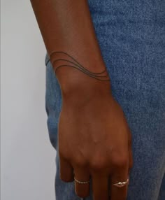 a close up of a person's hand with a small tattoo on their left wrist