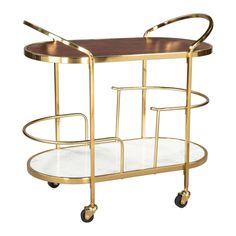 a brass serving cart with two glass shelves on casteors and wheels, designed in the style of art deco