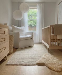 a baby's room with a crib, chair and bed in it is shown