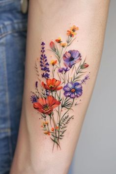 a woman's arm with colorful flowers and leaves on the left side of her body