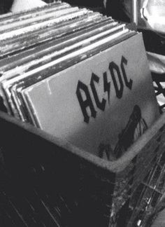 an old record player sitting on top of a wooden floor next to a pile of records