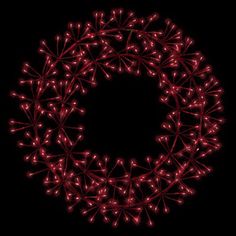 a red christmas wreath made out of small stars on a black background with copy space in the middle