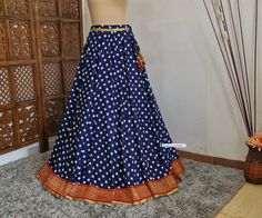 Made to Order/Made to Measurement/Custom Made Indian Lehenga Skirt (PLEASE NOTE THIS IS SKIRT ONLY) - Fabric: Polyester - Color : Navy Blue With Polka Dot Print - Fully Flared (8mtr) Kalidaar (Paneled)  Skirt - Lined - Red and Gold Banarasi Border - Drawstring closure with latkans This is Made To Order and we require following measurements in inches. 1. Waist of Skirt 2. Length of Skirt PLEASE NOTE: BUYERS ARE RESPONSIBLE FOR ANY CUSTOMS AND IMPORT TAXES THAT MAY APPLY. Fabric Care : Dry Clean Only Disclaimer: The actual color of the product might slightly differ from the image due to photographic lighting or monitor's display Shipping: This is made to order product. We customize the pattern of the dress to suit your style and fitting. Once you place the order we will provide you with a te Traditional Fitted Tiered Lehenga, Traditional Fitted Tiered Skirt, Festive Long Blue Skirt, Traditional Blue Lined Skirt, Traditional Long Blue Skirt, Traditional Blue Skirt For Festivals, Traditional Wedding Skirt, Flowy Style, Traditional Flowy Wedding Skirt, Traditional Wedding Flowy Skirt