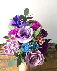 a vase filled with purple and blue flowers