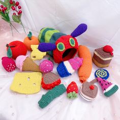 there are many crocheted items on the table together, including a toy caterpillar