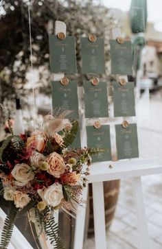 a bouquet of flowers sitting on top of a white easer next to a sign