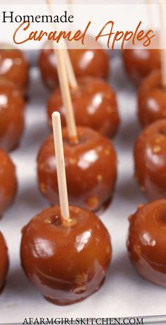 caramel apples with toothpicks in them on a tray