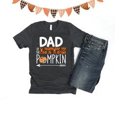 Dad of the little Pumpkin birthday shirt! We love this orange plaid print paired with the super cute patch print pumpkin - so cute for a fall theme birthday! We do have a matching one for Mom and the Birthday child in our shop. Every tee is handmade to order with love. Printed on our Unisex Adult Tees, these do run large. For a women's fit, we do suggest sizing down. For a looser fit, size as you would normally purchase. Please note since all tees are handmade, graphic placement may vary slightl Cute Father's Day Shirt With Crew Neck, Cute Crew Neck Shirt For Father's Day, Funny Print Cotton Top For Father's Day, Birthday Cotton Shirt With Funny Print, Fun Cotton Shirt For Birthday, Fun Cotton Birthday Shirt, Birthday Cotton Shirt With Text Print, Cute Cotton Shirt For Father's Day, Cute Orange Cotton Shirt