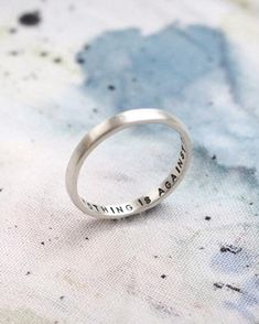 A modern reimagining of the classic Posey Ring, which were rings that were given as gifts with written messages on the inside of the band. This one is hand stamped with the positive affirmation ‘nothing is against me’ but you can personalise with your own wording inside the ring too. This 2mm wide silver ring is also perfect for stacking. Choose from black lettering for a bold message or to leave the letting uncoloured for a more subtle statement. Rings With Words, Posey Ring, Virgo Star Sign, Wide Silver Ring, Stamped Rings, Bridesmaid Bracelet, Positive Affirmation, Alphabet And Numbers, Classic Ring