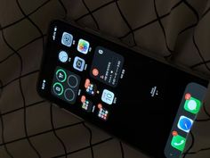 an iphone with various icons displayed on the screen and in front of a black background