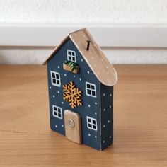 a small blue house with a snowflake on the roof