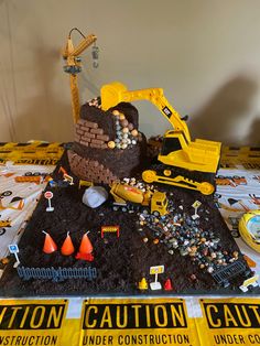 there is a construction themed cake on the table with caution tape around it and other decorations