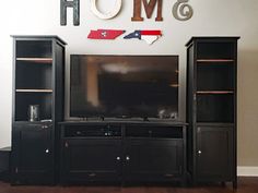 a flat screen tv sitting on top of a wooden entertainment center