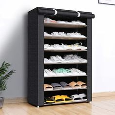 a black shoe rack with shoes on it in a room next to a potted plant