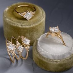 three pieces of jewelry sitting on top of a velvet ring box next to each other