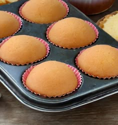 a muffin tin filled with cupcakes on top of a wooden table