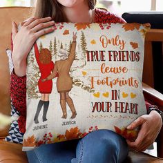 a woman sitting on a couch holding a pillow with an image of two women hugging each other