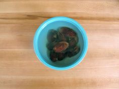 a blue bowl filled with nuts on top of a wooden table