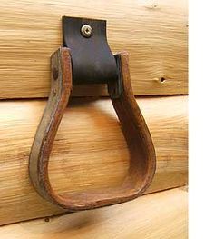 a close up of a wooden door handle on a wood paneled wall with a metal hook