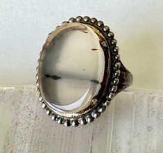 "a fabulous old Uncas ring with an equally wonderful agate.  this was likely made in the 1920's.  the stone is set with a low bezel and four prongs.  the agate is mostly clear with a few little strokes of brown, and it's in lovely condition.  inner band is marked sterling with the Uncas hallmark.  there is some glue around the edges of the stone and some patina, light wear. size:  measures a 6.25, fits more like a 6.5 height of face:  7/8\" width of inner band:  a bit over 1/16\"" Red Gemstone Ring, Multi Sapphire, Vintage Bell, Red Gemstones, Agate Ring, Green Turquoise, Gemstone Ring, Rings Statement, Beautiful Rings