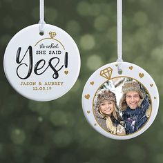 two personalized christmas ornament hanging from a tree with pine cones in the background