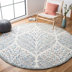 a white and blue area rug in a living room with a chair next to it