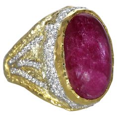 Elevate your elegance with the unparalleled splendor of this magnificent ring, masterfully designed by the celebrated artisan Victor Velyan. This opulent piece features a breathtaking 22.15-carat cabochon ruby, a gemstone revered for its deep, velvety red hue and captivating luster. The ruby, with its smooth, polished surface, exudes an aura of timeless sophistication and grandeur. Set in a luxurious blend of 18K and 24K yellow gold, the ring showcases Velyan's exceptional craftsmanship and his ability to create pieces that are both bold and refined. Surrounding the central ruby are 1.09 carats of exquisite diamonds, expertly set to enhance the ruby's radiant glow, creating a stunning interplay of light and color. This piece is not just a ring; it's a masterpiece that reflects a legacy of Luxury Ruby Ring Oval Cabochon With Polished Finish, Luxury Ruby Ring With Oval Cabochon, Luxury Ruby Ring Oval Cabochon, Luxury Ruby Ring Oval Cabochon Polished Finish, Luxury Victorian Cabochon Ruby Ring, Ruby Diamond, Gold Gold, Unique Gemstones, Belleza Natural