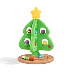 a green toy tree with lots of colorful balls on it's face and eyes