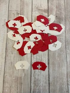 red and white paper hearts with crosses cut out of them sitting on a wooden surface