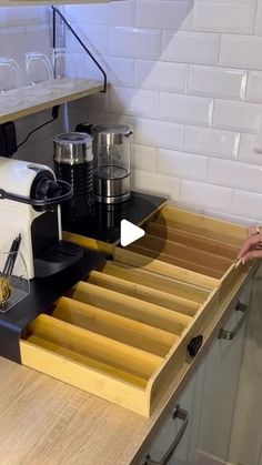 a coffee maker sitting on top of a kitchen counter next to a drawer with drawers