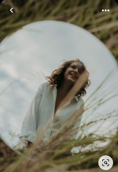 a woman standing in front of a round mirror