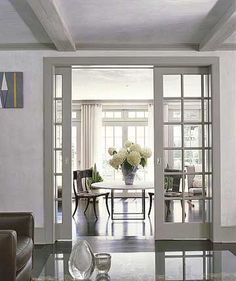 a living room filled with lots of furniture and flowers on top of a glass table