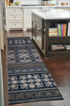 a kitchen area with a rug on the floor next to a sink and counter top