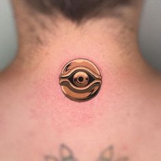 the back of a man's neck with an eye tattoo on it