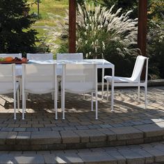 a white table and chairs sitting on top of a brick patio