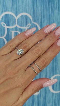 a woman's hand with pink manicured nails and a diamond ring