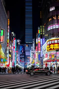 a busy city street at night with neon signs and buildings in the background, japan