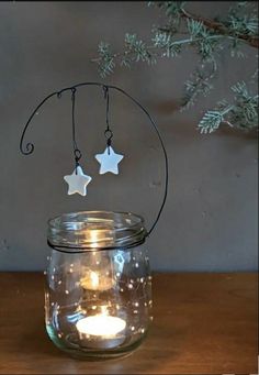 a glass jar with two stars hanging from it