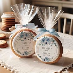 two cookies wrapped in clear cellophane and tied with blue ribbon are sitting on a table