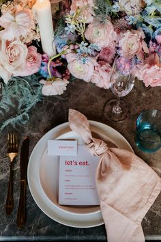 a place setting with flowers and candles