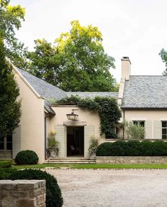 a large white house surrounded by trees and bushes