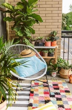 an outdoor patio with potted plants and rugs