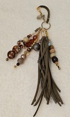 a keychain with beads and charms hanging from it's side on a white surface