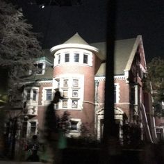 a person walking past a large building at night