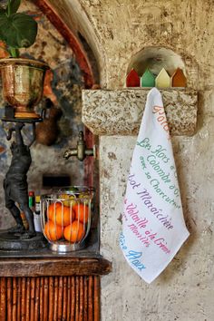 there is a towel hanging on the wall next to some oranges and a potted plant