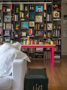 the room is full of bookshelves and children's artwork on display in it