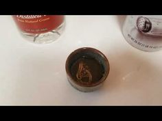 an empty cup sitting on top of a white counter next to a bottle of alcohol