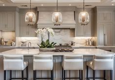 a large kitchen with marble counter tops and white stools