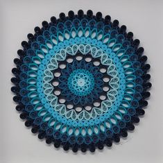 a blue and black paper doily on a white surface with circles in the center