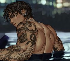 a man with tattoos sitting in the water looking down at his arm and shoulder tattoo